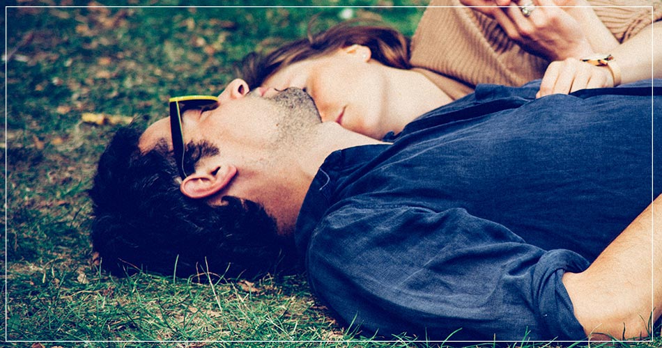 Couple d'expatriés allongé dans l'herbe