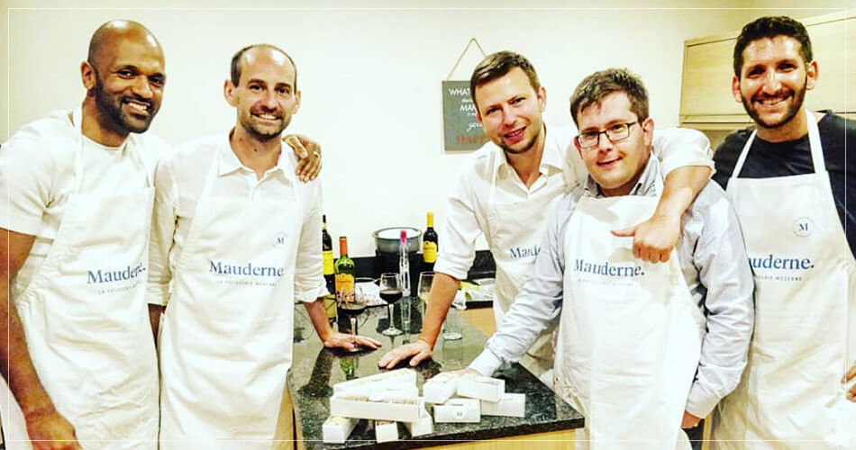Cinq étudiants souriants au cours de cuisine Mauderne à Londres