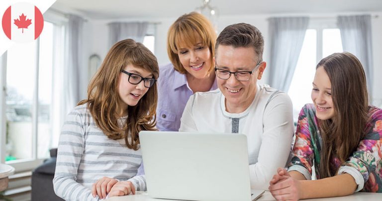 Famille canadienne dans le salon avec ordinateur portable
