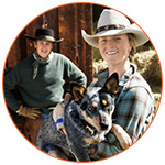 Jolie cowgirl souriante avec son chien dans les bras