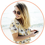 Jolie jeune femme sur la plage avec son smartphone