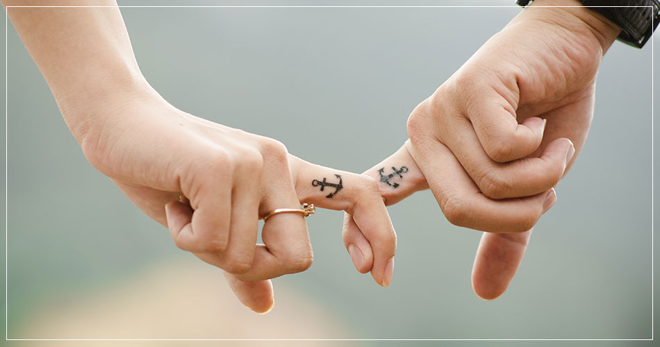 Gros plan sur les mains et doigts tatoués d'un couple