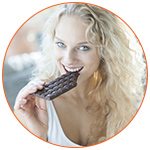 Jolie femme croquant une barre de chocolat