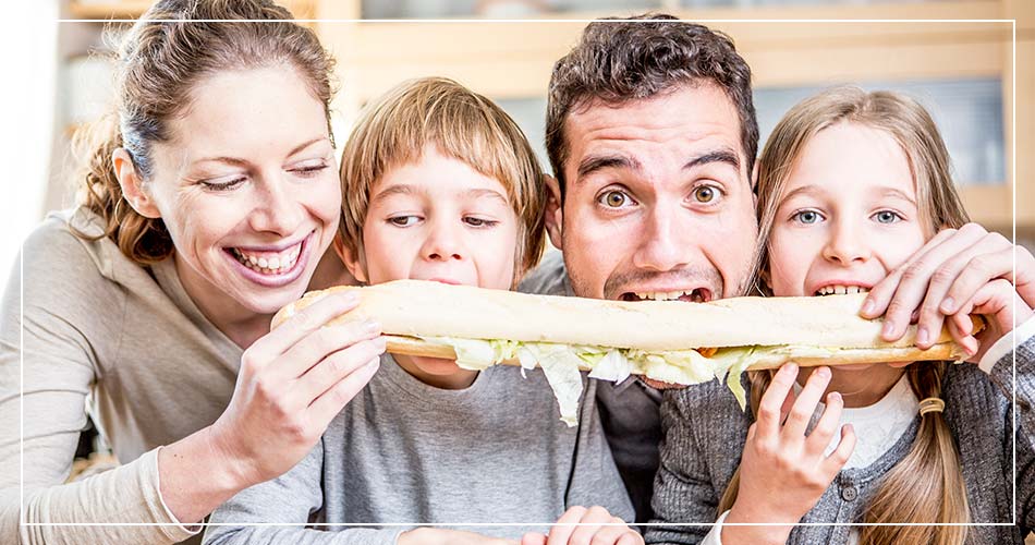 Famille française qui mange une longue baguette de pain