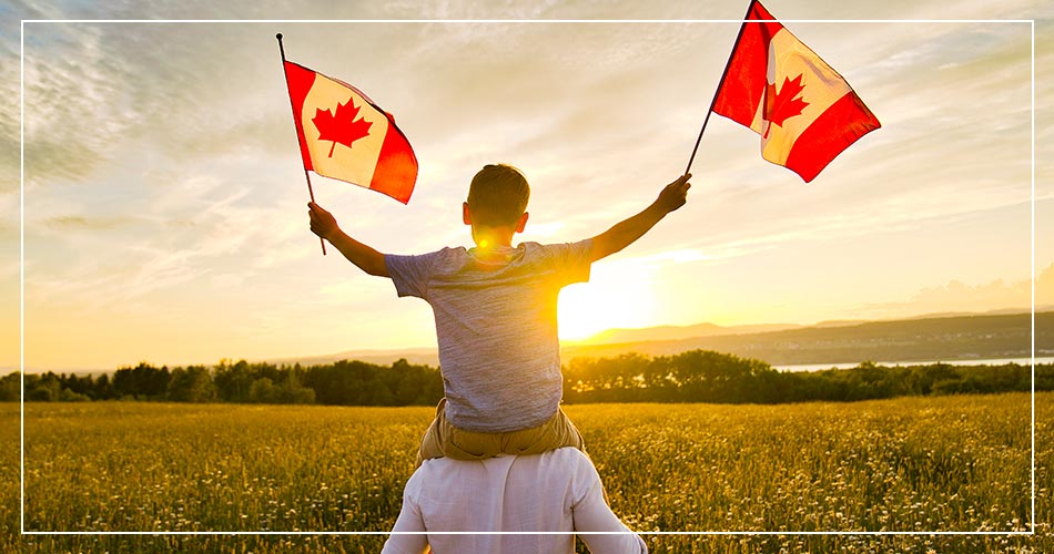 Jeune canadien sur les épaules de son père brandissant le drapeau canadien
